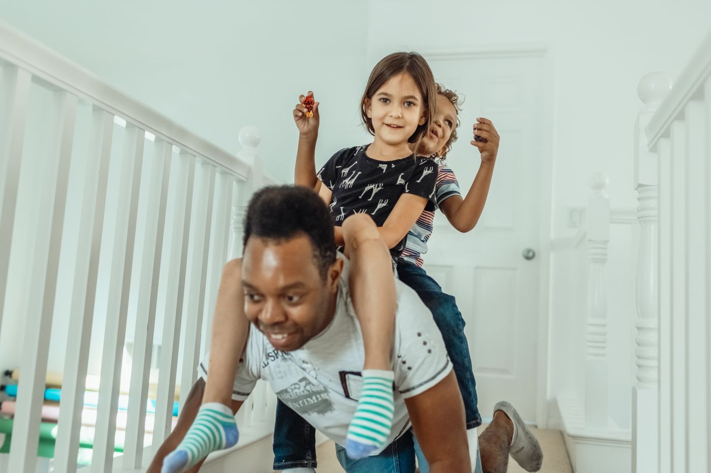 A father carrying his children at home